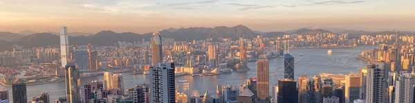 Desert camp at dusk with silhouetted mountains against an orange sky